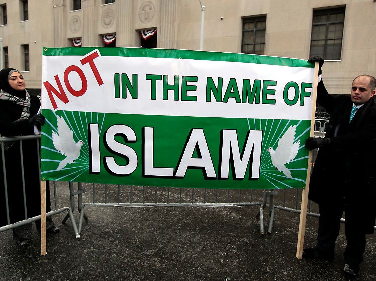 Vor dem Gerichtsgebäude distanzieren sich Muslime von Gewalt.