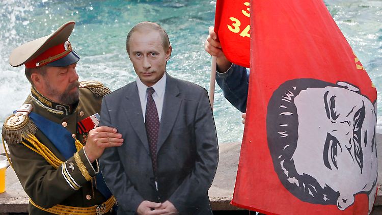 Russische Geschichte für einen Touristen-Schnappschuss: Putin-Pappkamerad zwischen einem Zar-Nikolaus-Darsteller und einer Stalin-Fahne in Moskau.