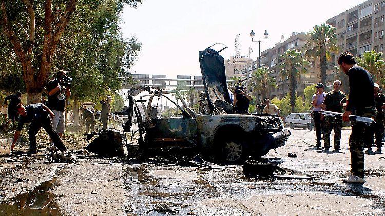 Das Bild der staatlichen Nachrichtenagentur Sana zeigt Polizisten, die ein Auto untersuchen, dass in Damaskus explodierte.
