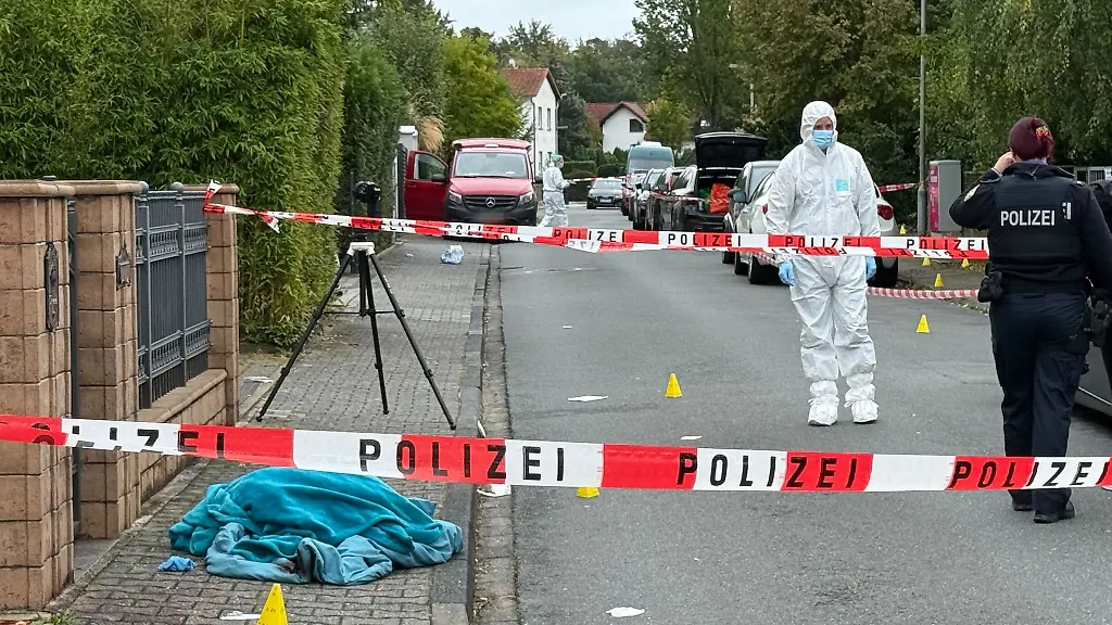 Polizei-und-Spurensicherung-arbeiten-hinter-einer-Absperrung-nachdem-Schuesse-gefallen-sind