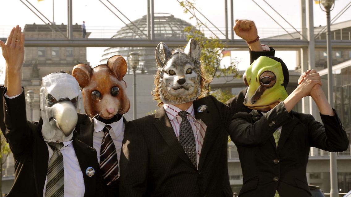 Aktivisten des NABU, verkleidet als Politiker mit Tiermasken, posieren vor der Kuppel des Reichstages. Mehrere Umweltverbände fordern von der Bundesregierung, die Ökologie zum Topthema zu erklären.
