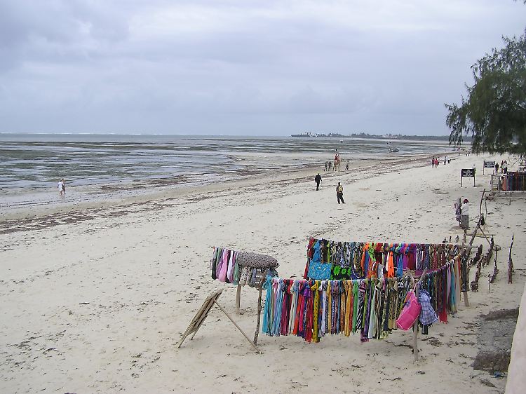 Einheimische warten am Bamburi-Strand in Kenia auf Touristen, denen sie Souvenirs, Strandtücher, Bootsfahrten, Safaris oder Landausflüge verkaufen können.