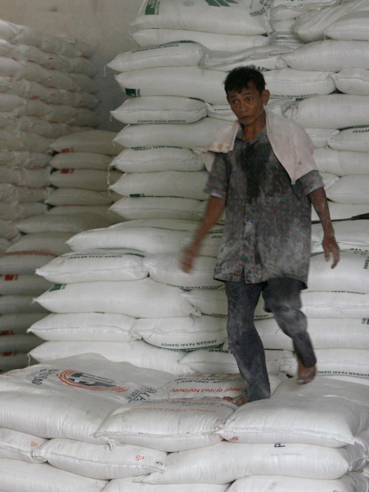 Alles auf Zucker: Ein Arbeiter läuft in einer Lagerhalle in Djakarta, Indonesien, über einen Stapel von Zucker-Säcken.
