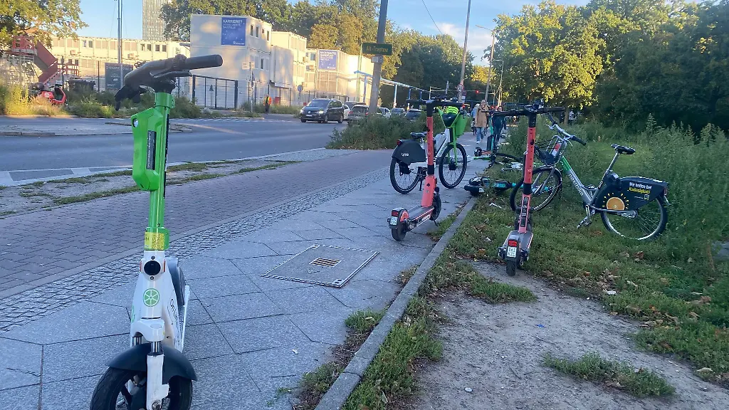 E-Roller-verschiedener-Anbieter-liegen-und-stehen-auf-dem-Gehweg-in-Berlin-Kreuzberg