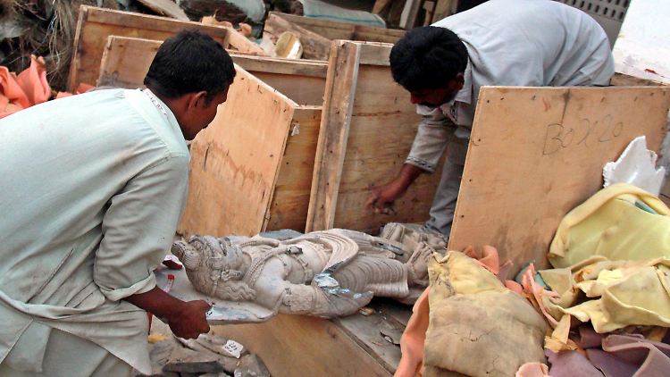 Pakistanische Polizisten öffnen Truhen mit historischen Skulpturen, die zuvor bei einem Kunstraub gestohlen worden waren.