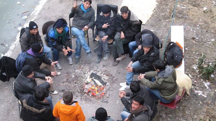 In der Hoffnung vereint: In kleinen Gruppen wärmen sich die Flüchtlinge am Feuer.