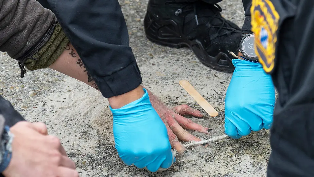 Speziell-geschulte-Polizisten-versuchten-die-Haende-von-Demonstranten-von-der-Strasse-zu-loesen