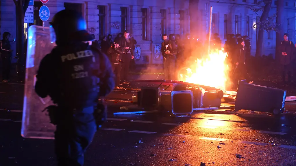 Polizisten-stehen-auf-der-Eisenbahnstrasse-in-Leipzig-vor-brennenden-Gegenstaenden