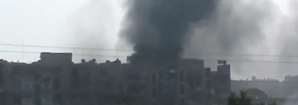 Aleppo unter Beschuss: Dunkle Rauchwolken über einer zerstörten Häuserfront.