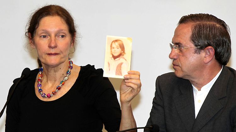 Christine Assange zeigt ein Kinderfoto ihres Sohnes Julian Assange. Daneben sitzt Ecuadors Außenminister Ricardo Patiño.