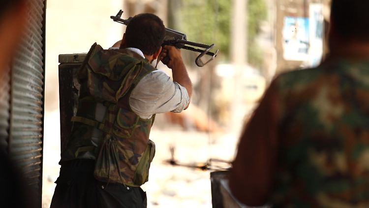 Ein Aufständischer schießt in Aleppo auf Assads Truppen.