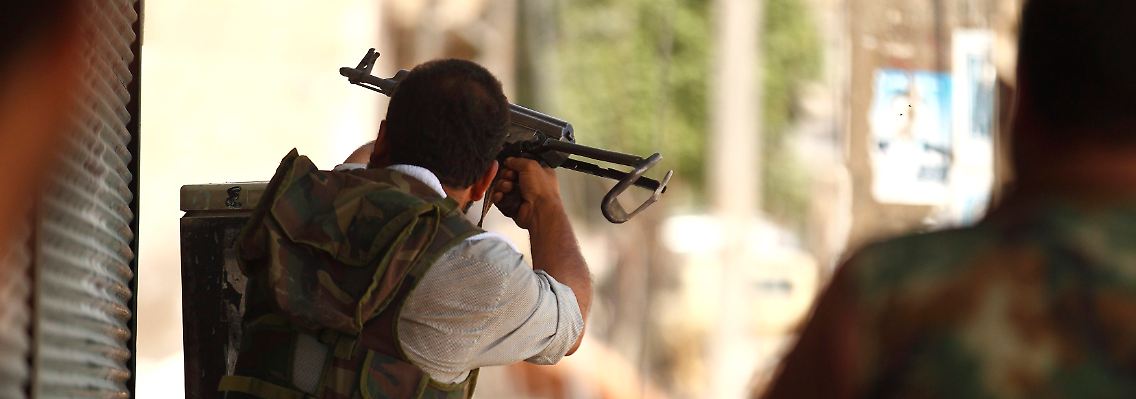 Ein Aufständischer schießt in Aleppo auf Assads Truppen.