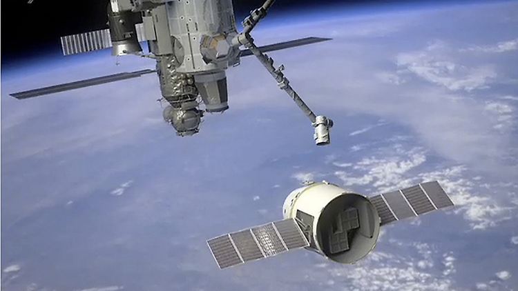 Computerillustration der Nasa zeigt eine unbemannte Space X-Kapsel "Dragon", die vom Roboterarm der ISS gepackt und in die richtige "Parkposition" gebracht wird.