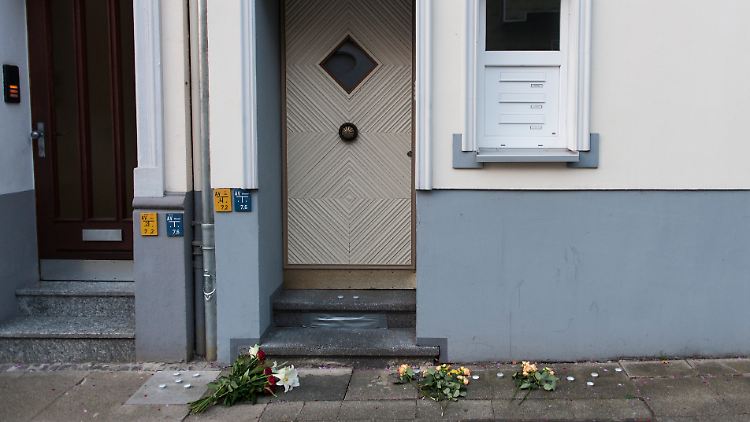 Blumen liegen vor dem Haus in Essen, in dem Ermittler die Leichen einer Mutter und ihrer Tochter gefunden haben.