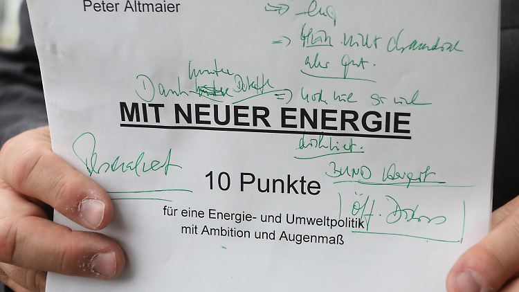 Altmaier hält sein handbeschriebenes Exemplar des Arbeitspapieres in die Kameras.