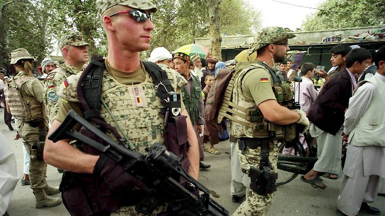 Bewaffnete Soldaten des deutschen ISAF-Kontingents patrouillieren auf dem Markt in Talokan.