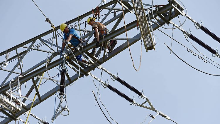 Monteure auf einem Hochspannungsmast in der Nähe von Erfurt.