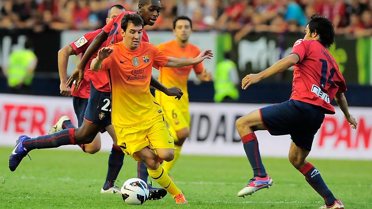 Superstar Lionel Messi aus Argentinien dribbelt Osasuna's Joseba Llorente aus.
