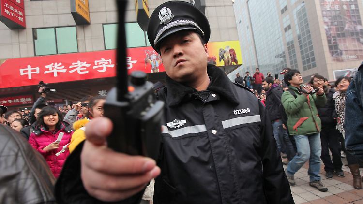 Ein chinesischer Polizist vertreibt Journalisten, die über eine Protestaktion der "Jasmin Revolution" in Peking berichten wollen