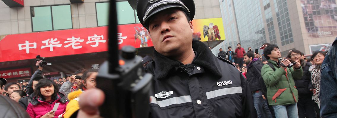 Ein chinesischer Polizist vertreibt Journalisten, die über eine Protestaktion der "Jasmin Revolution" in Peking berichten wollen