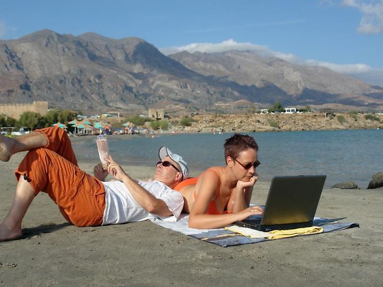 Muss nur noch kurz die Welt retten: Wer mit den Gedanken oder per Laptop und Handy noch halb im Job festhängt, erholt sich im Urlaub weniger.