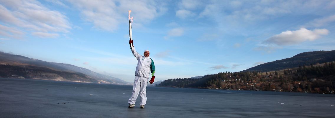 Adam Medrek steht mit der Fackel auf dem gefrorenen Wood Lake in Lake Country (British Columbia).