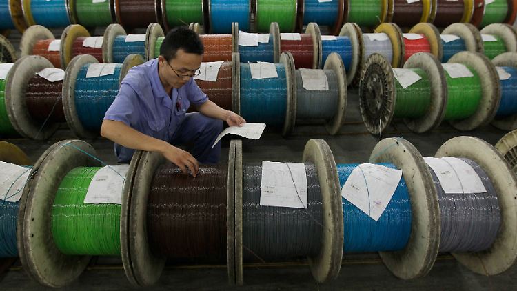 In einer Fabrik in Wuhan kontrolliert ein Mitarbeiter Glasfaserkabel.
