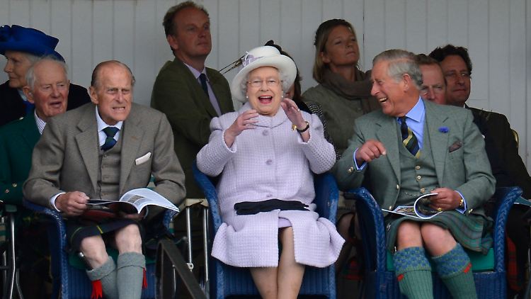 Vergnügt zeigen sich Queen Elizabeth II., Prinz Philip und Prinz Charles bei den Highland-Games.