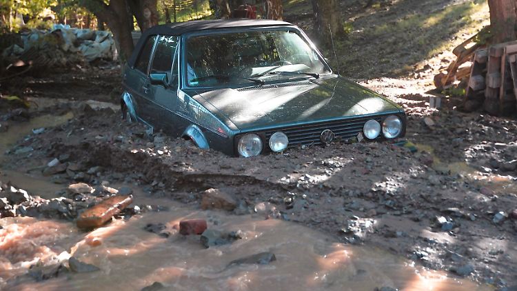 Ein Golf-Cabrio steht nach dem rohrbruch tief im Schlamm.