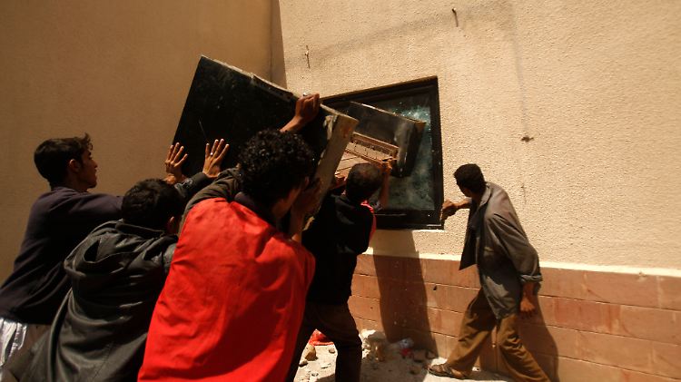 Protestler zerstören ein Fenster der US-Botschaft in Sanaa.