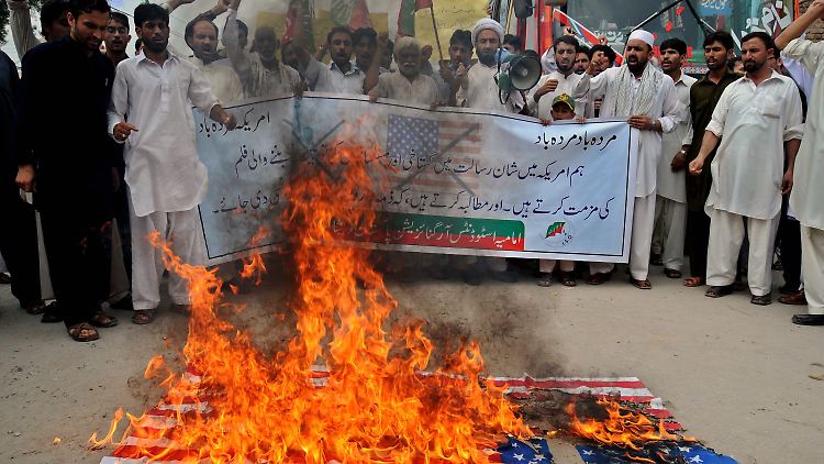 Demonstranten verbrennen in Pakistan eine US-Fahne.