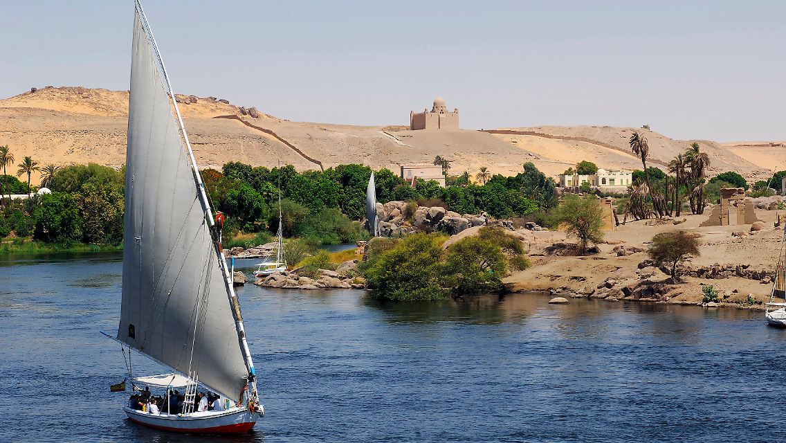 Eine Felukke mit Urlaubern und das Mausoleum des Aga Khan: Bei Assuan bietet der Nil viele interessante Perspektiven.