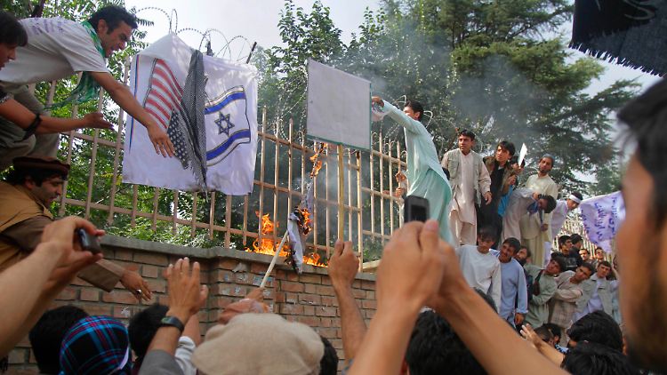 Demonstranten verbrennen eine  in Kabul amerikanische und eine israelische Flagge.