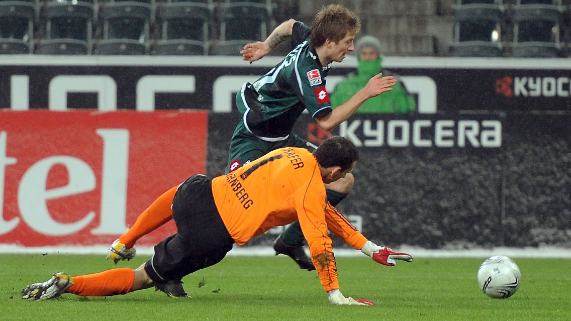 Der Mönchengladbacher Marco Reus bereitet das 1:0 vor, indem er den Nürnberger Torwart Raphael Schäfer (r) ausspielt.