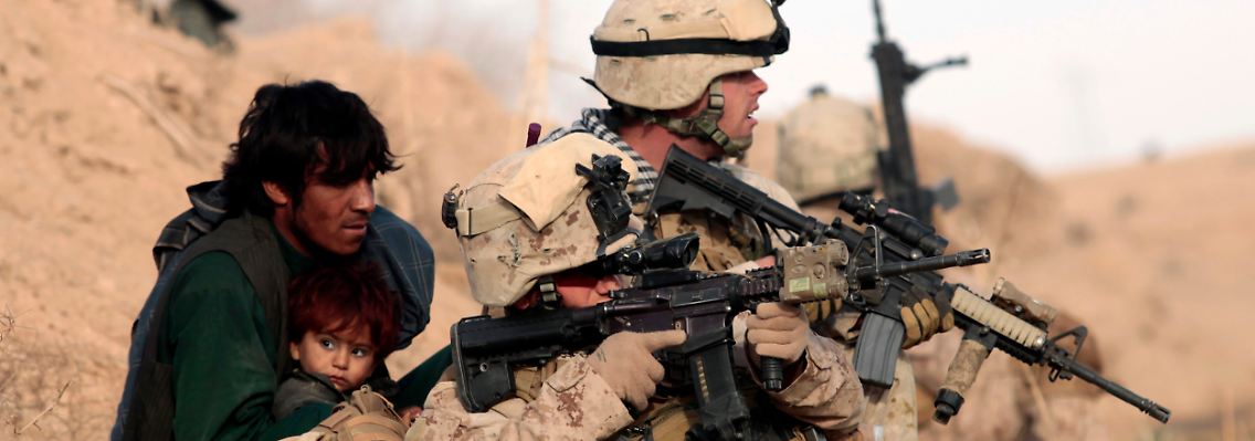 Ein US-Soldat beschützt einen Afghanen mit seinem Kind, nachdem Taliban-Kämpfer in Mardscha das Feuer eröffnet haben.
