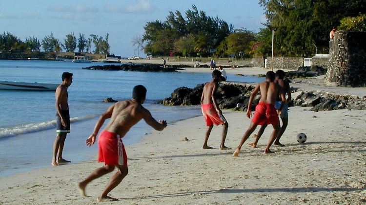 Jugendliche Fußballspieler am Strand von Pereybere auf Mauritius.