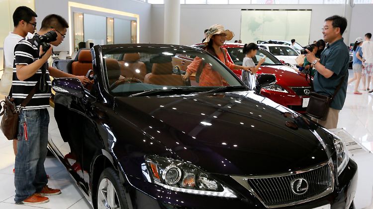 Chinesische Touristen in einem Toyota-Showroom in Tokio.