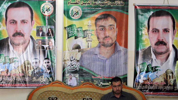 Der Palästinenser Fayeq el-Mabhuh sitzt vor den Porträts seines Bruders und Hamas-Kommandeurs Mahmud el-Mabhuh, (l und r).