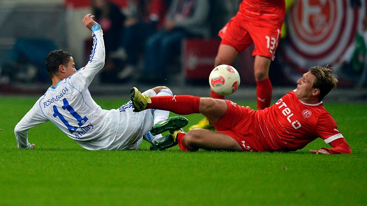 Voronin (r.) kugelt sich mit Afellay auf dem satten Grün.