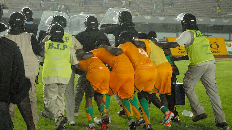 "Essen, Getränke, alles was man werfen kann, flog auf den Platz": Die Spieler der Elfenbeinküste versuchen in Dakar, den Platz zu verlassen.