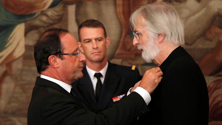 Frankreichs Präsident Hollande steckt Haneke den Orden an.