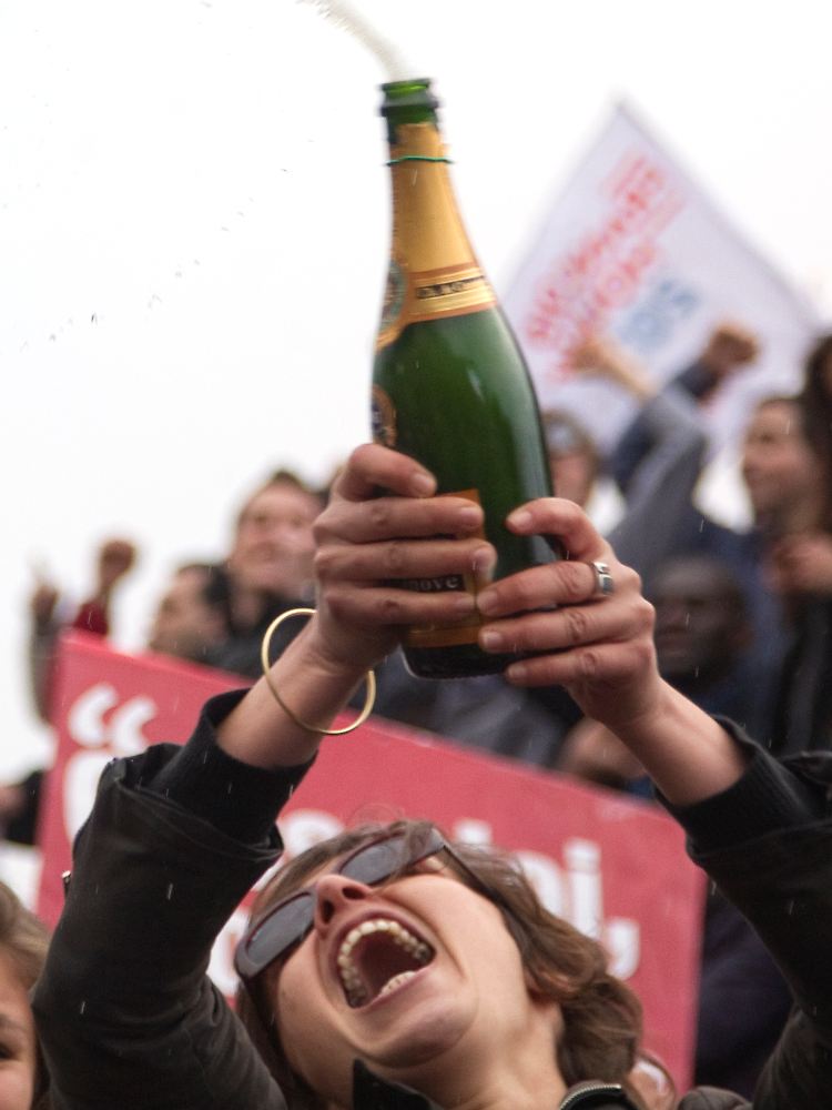 Champagner, das getränk für besondere Anlässe - heir feiert eine Hollande-Anhängerin in Paris seinen Wahlsieg im Mai 2012.