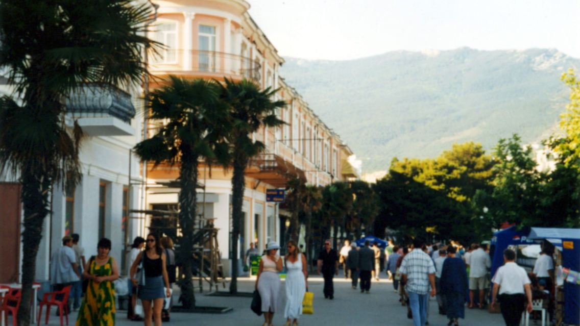 Vor dem Hotel Marino schlendern Touristen und Einheimische über die Strandpromenade der Hafenstadt Jalta.