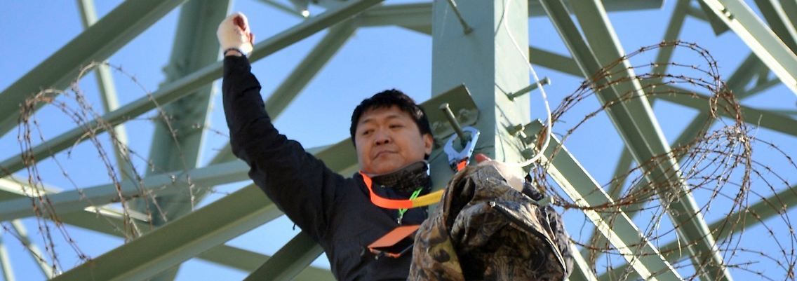 Mit warmer Kleidung, Fahne und Plastiktüten.