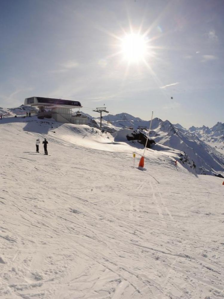 Skifahrer im Sylvretta Skigebiet über dem Skiort Ischgl.