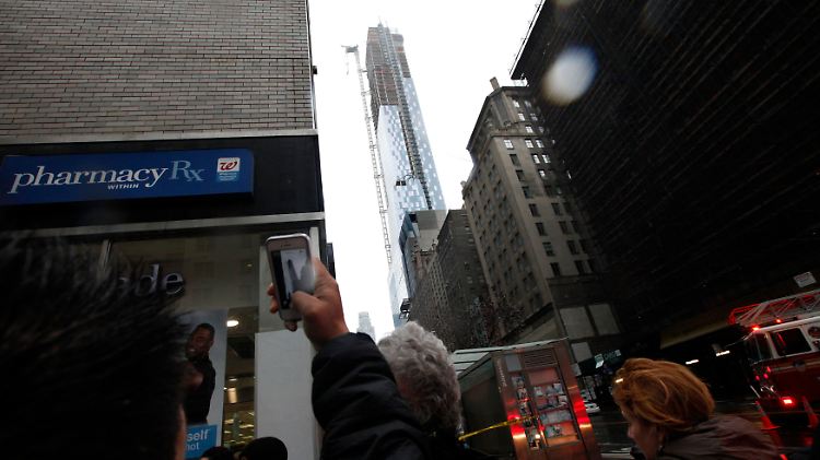 Bange Blicke hoch zu einem Wolkenratzer in Manhattan, an dem ein Hochkran zusammenbrach.