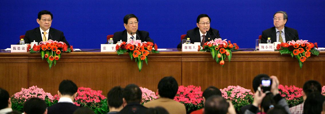 Ernste Mienen hinter sozialistischen Blumenschmuck von links nach rechts: Wirtschaftsminister Chen Deming, Reformkommissar Zhang Ping, Finanzminister Xie Xuren und Zentralbankchef Zhou Xiaochuan.