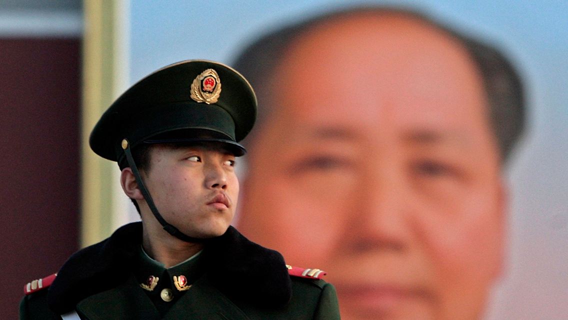 Ein Polizist hält auf dem Platz des himmlischen Friedens in Peking Wache - hinter ihm ein Portrait von Mao Tse-tung.