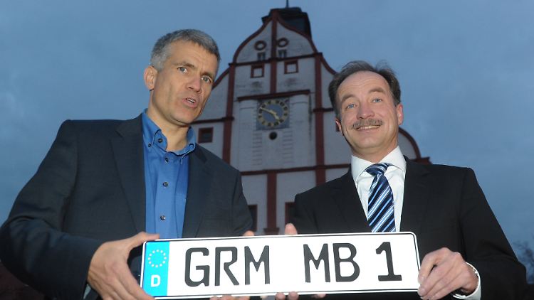 Sachsens Wirtschaftsminister Sven Morlok (r.) überreicht vor dem Rathaus in Grimma das Heimatkennzeichen mit der Kürzel "GRM" für Grimma an den Bürgermeister Matthias Berger.