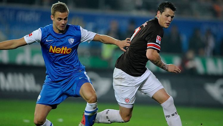 Holmar Örn Eyjolfsson (l.) und St. Paulis Daniel Ginczek bei der Rasenschlacht um den Ball.